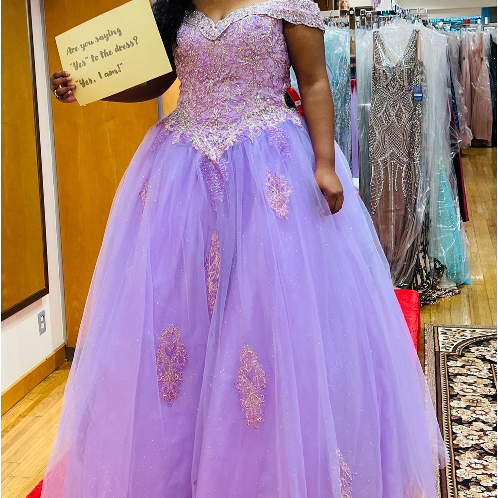 The dress is a lilac princess prom dress. The size is an 18.